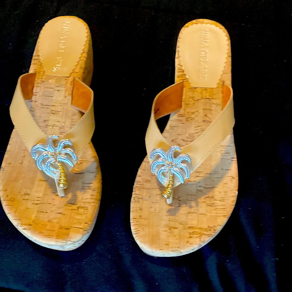 Palm tree beige patent leather sandals with cork soles.